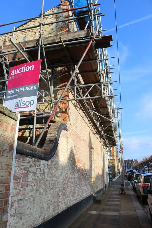 A building in disrepair with scaffold around
