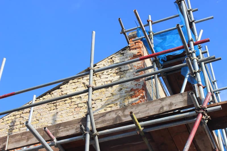 Building in disrepair with scaffold supporting it