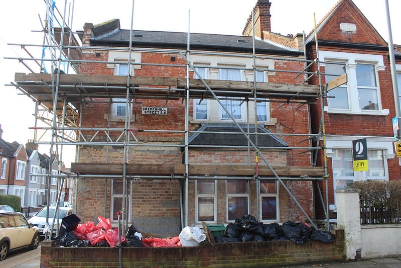 A building in disrepair with scaffold around